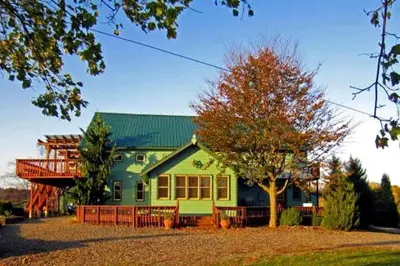 a green house with a tree in front of it at Pet-Friendly Vacation Rental on a Working Farm near Hudson, New York in Hudson
