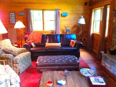 a living room with a couch and a coffee table at Cozy Log Cabin with a Private Hot Tub near Beartown State Forest, Massachusetts in Monterey