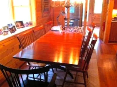 a wooden dining table and chairs in a room at Cozy Log Cabin with a Private Hot Tub near Beartown State Forest, Massachusetts in Monterey