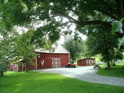 a red barn with a motorcycle parked in front of it at Enchanting Secluded Cabin Rental near Salem, New York in Salem