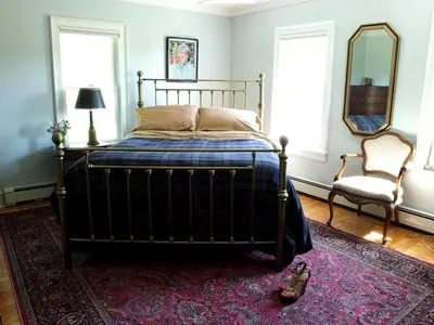 a bedroom with a bed and a mirror and a chair at Enchanting Secluded Cabin Rental near Salem, New York in Salem