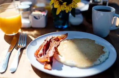 a white plate with breakfast food on a table at Stylish Camping Tents Set on an Organic Farm in Hudson Valley, New York State in Ghent