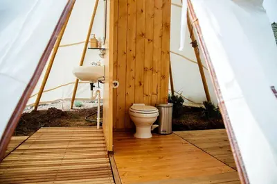 a bathroom in a boat with a toilet in it at Stylish Camping Tents Set on an Organic Farm in Hudson Valley, New York State in Ghent