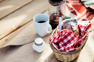 a basket of bread and a cup of coffee on a table at Stylish Camping Tents Set on an Organic Farm in Hudson Valley, New York State in Ghent