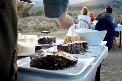 a table with a plate of chocolate cake on it at Stylish Camping Tents Set on an Organic Farm in Hudson Valley, New York State in Ghent