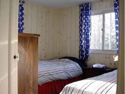 a bedroom with a bed and a window with blue curtains at Secluded Family Mountain Rental with Fireplace in Windham, New York in Windham