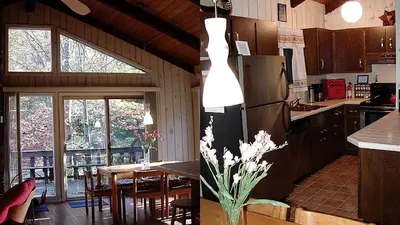 a kitchen and dining room with a table and a refrigerator at Secluded Family Mountain Rental with Fireplace in Windham, New York in Windham