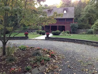 a house with a gravel driveway in front of a yard at Romantic Year-Round Cabin Getaway with Free Wi-Fi in Saugerties, New York in Saugerties