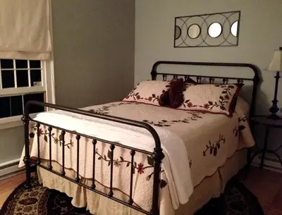 a bedroom with a bed with a metal frame at Romantic Year-Round Cabin Getaway with Free Wi-Fi in Saugerties, New York in Saugerties
