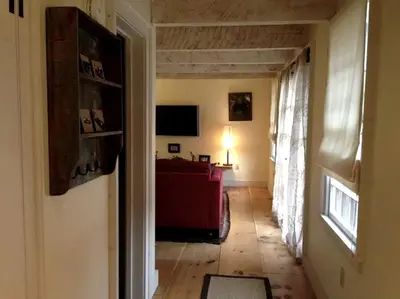 a hallway with a living room with a couch and a window at Romantic Year-Round Cabin Getaway with Free Wi-Fi in Saugerties, New York in Saugerties