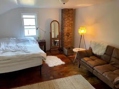 a living room with a bed and a couch at Lovely Farmhouse Cabin with Incredible Landscape Views in New York in Worcester