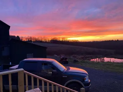 a truck parked in front of a sunset at Lovely Farmhouse Cabin with Incredible Landscape Views in New York in Worcester