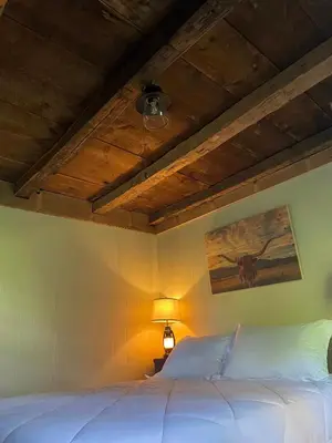 a bedroom with a white bed with a ceiling at The Red Country Cottage in Amenia