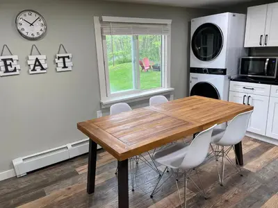 a kitchen with a wooden table and white appliances at The Red Country Cottage in Amenia