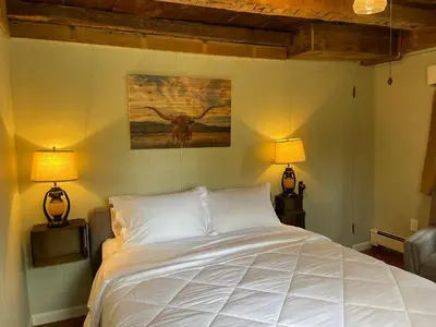 a bedroom with a large white bed with two lamps at The Red Country Cottage in Amenia