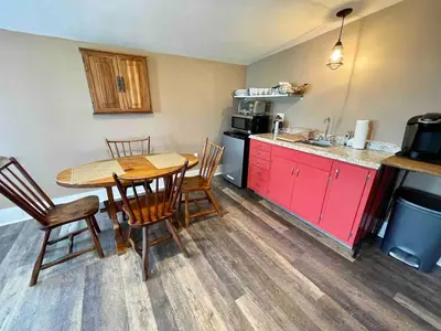 a kitchen with a table and chairs and a kitchen with a counter at Hoppy Hill Farm House in Dover Plains
