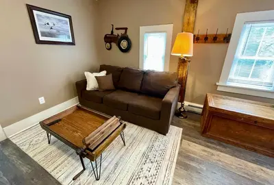 a living room with a brown couch and a coffee table at Hoppy Hill Farm House in Dover Plains