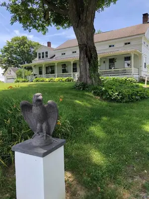 a statue of an eagle sitting in front of a house at Hoppy Hill Farm House in Dover Plains
