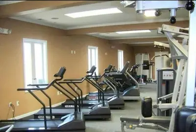 a gym with a row of treadmills and machines at The Hut House 3BR 3BA Game Room Massage Chair in Lake Ariel