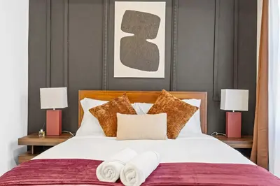 a bedroom with a large bed with two lamps at Mid-Century Stay 5BR and 5 Baths w PS5 & Laundry in Brooklyn