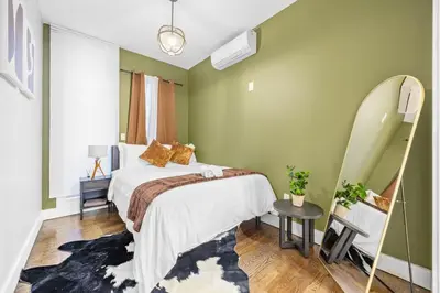a green bedroom with a bed and a mirror at Mid-Century Stay 5BR and 5 Baths w PS5 & Laundry in Brooklyn