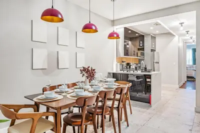 a kitchen and dining room with a wooden table and chairs at Mid-Century Stay 5BR and 5 Baths w PS5 & Laundry in Brooklyn