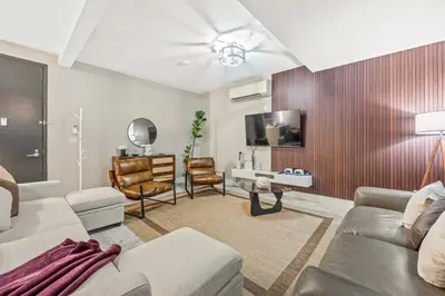 a living room with a couch and a tv at Mid-Century Stay 5BR and 5 Baths w PS5 & Laundry in Brooklyn