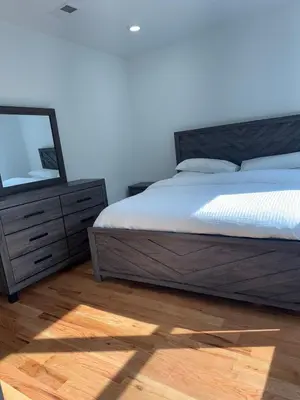 a bedroom with a bed with a mirror and a dresser at Cozy 3BR Retreat with Rooftop Near EWR & NYC Access in Newark