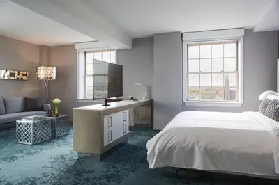 a bedroom with a bed and a tv and a couch at Renaissance Albany Hotel in Albany