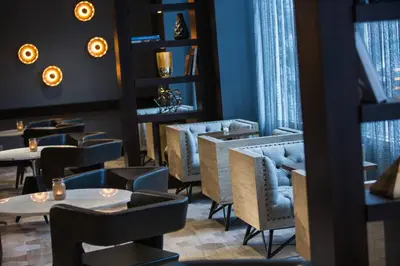 a restaurant with tables and chairs and windows at Renaissance Albany Hotel in Albany