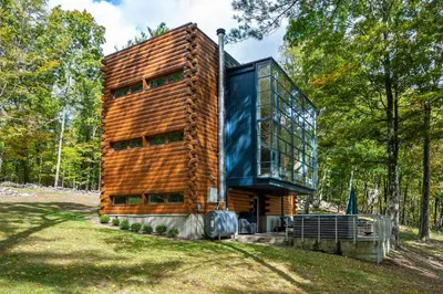 a wooden house in the middle of a forest at Epic architectural masterpiece views & hot tub in Accord