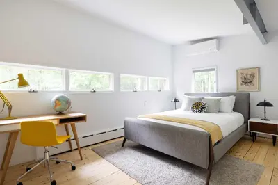 a bedroom with a bed and a desk and windows at Epic architectural masterpiece views & hot tub in Accord