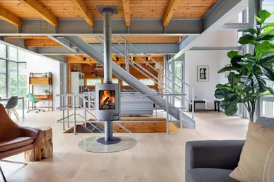 a fireplace in a living room with a staircase at Epic architectural masterpiece views & hot tub in Accord