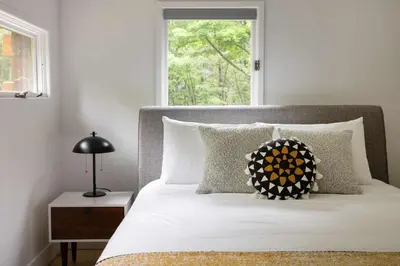a bed with a pillow on it with a window at Epic architectural masterpiece views & hot tub in Accord