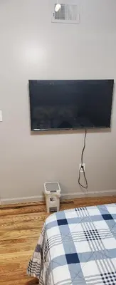 a bedroom with a flat screen tv on the wall at Joy queen room 6A in Newark