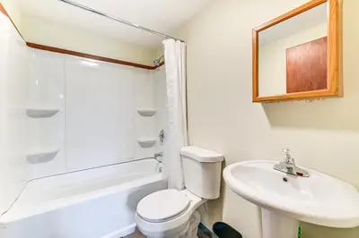 a white bathroom with a sink and a toilet at Lake-View Cabin with Furnished Deck in Hadley! in Hadley