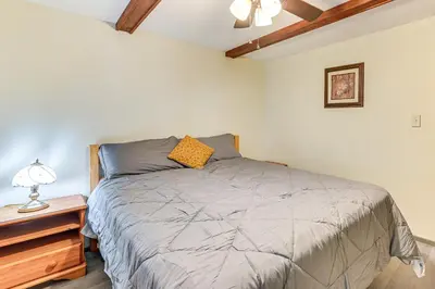a bedroom with a bed and a night stand with a lamp at Lake-View Cabin with Furnished Deck in Hadley! in Hadley