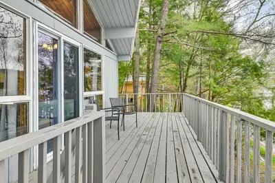 a porch with a table and chairs on a house at Lake-View Cabin with Furnished Deck in Hadley! in Hadley