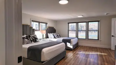a hotel room with two beds and two windows at Catskills Escape Hot Tub Massage Chairs & Games in Round Top