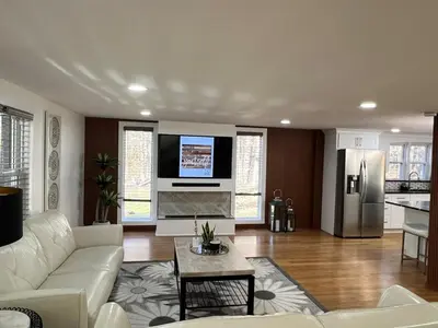 a living room with a white couch and a refrigerator at Catskills Escape Hot Tub Massage Chairs & Games in Round Top