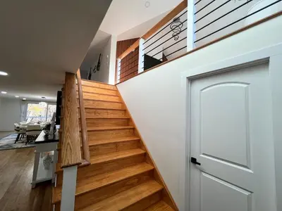 a wooden staircase with a white door in a house at Catskills Escape Hot Tub Massage Chairs & Games in Round Top