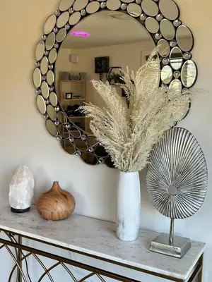 a mirror on a wall with a vase on a table at Catskills Escape Hot Tub Massage Chairs & Games in Round Top