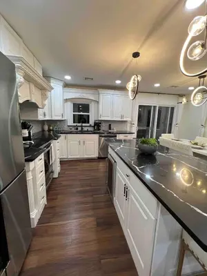a kitchen with white cabinets and stainless steel appliances at Modern getaway in Catskills in Cairo