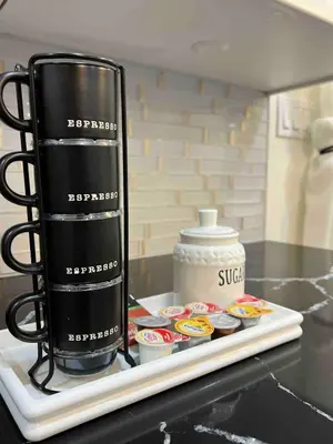 a black coffee mug sitting on a tray with cupcakes at Modern getaway in Catskills in Cairo
