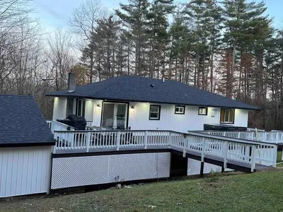 a white house with a porch and a fence at Modern getaway in Catskills in Cairo