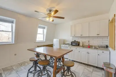 a kitchen with a wooden table and some stools at 1 Mi to Dtwn Schenectady Apt in Stockade District in Schenectady