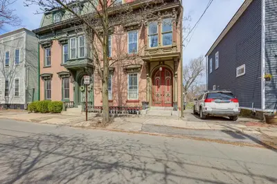 a car parked in front of a building with a red door at 1 Mi to Dtwn Schenectady Apt in Stockade District in Schenectady