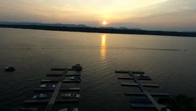 a group of boats in the water at sunset at Charming Camping Cabin on the Shores of Great Sacandaga Lake in Northville, New York in Northville