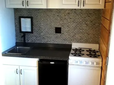 a kitchen with a stove and a sink at Charming Camping Cabin on the Shores of Great Sacandaga Lake in Northville, New York in Northville