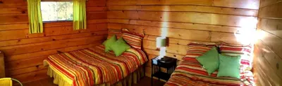 a room with two beds in a log cabin at Charming Camping Cabin on the Shores of Great Sacandaga Lake in Northville, New York in Northville